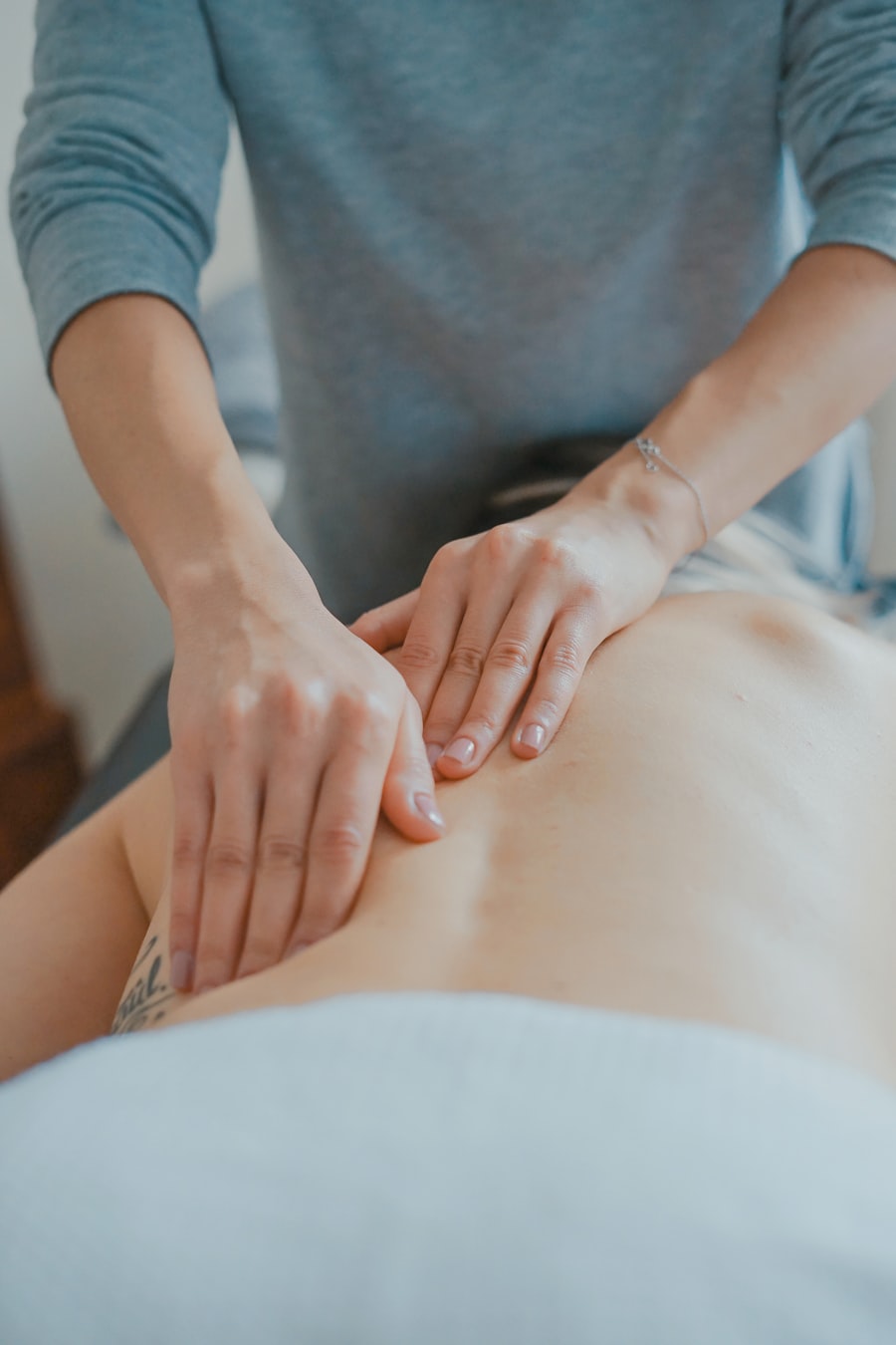 Slow, rhythmic massage strokes across a client's back